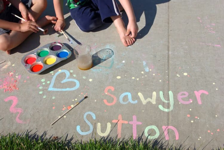 colorful chalk paint being played with outside by kids