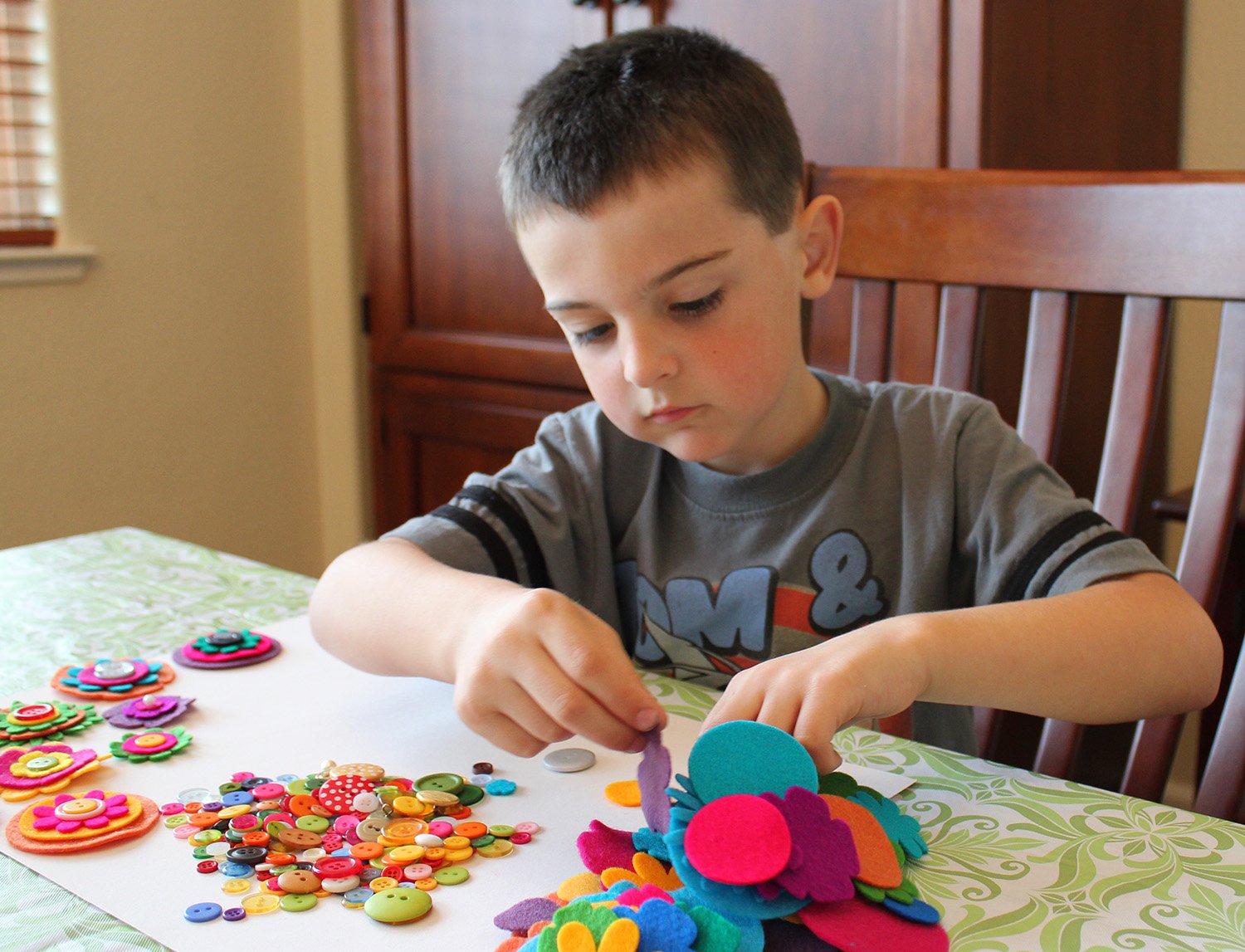 small boy working with felt flower pieces