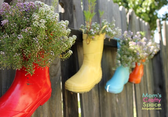 hanging rain boot pots filled with flowers 