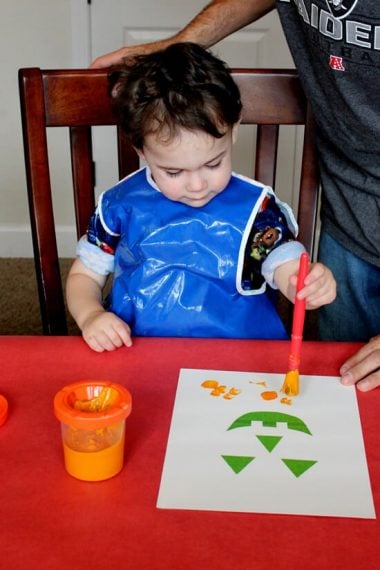 kids sitting at table painting halloween art