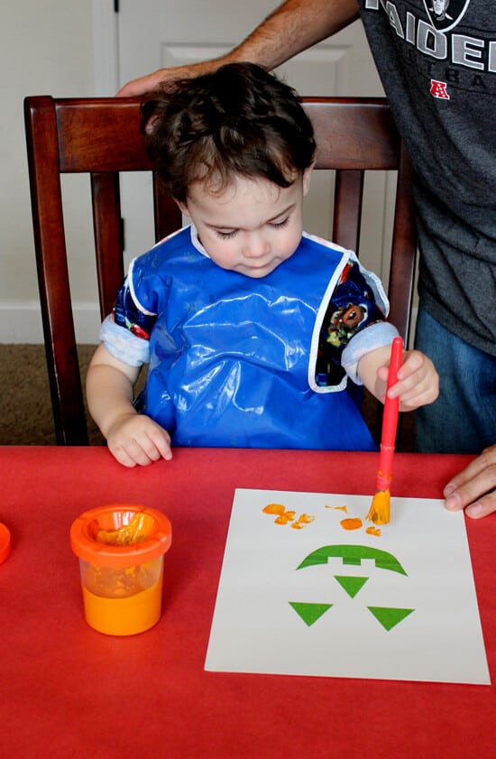 kids sitting at table painting halloween art