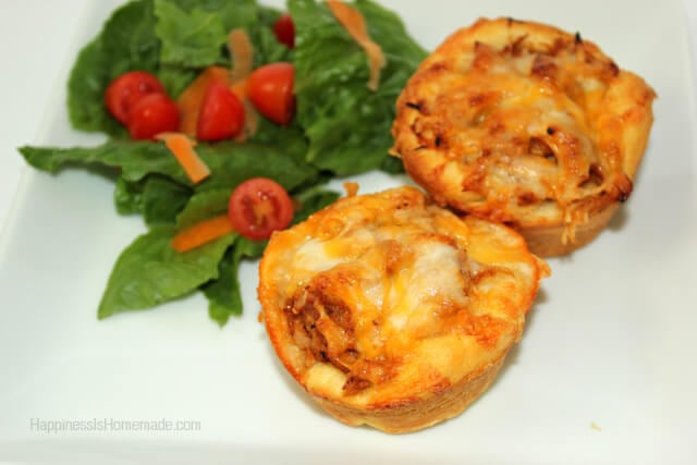 two barbecue chicken muffins on a white plate with side of green salad and tomatoes