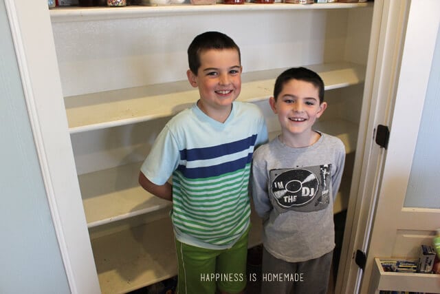 kids smiling in front of empty pantry shelves
