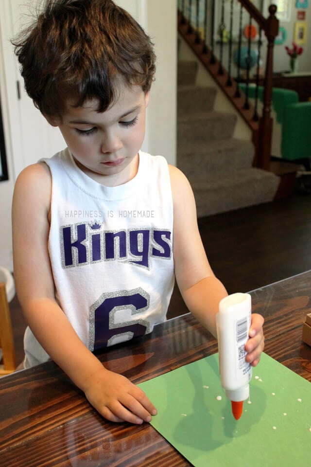 child using glue on kids craft activity