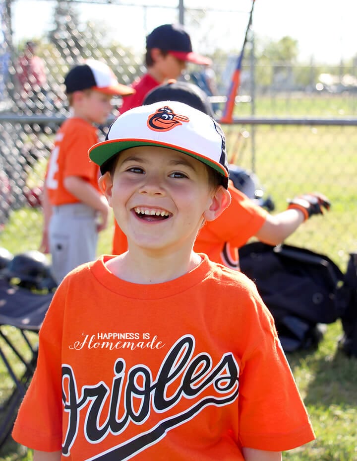 cute boy smiling and happy at baseball game