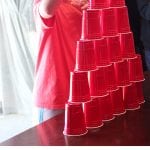 Minute to Win It Games: Stack Attack, shows small boy stacking red cups