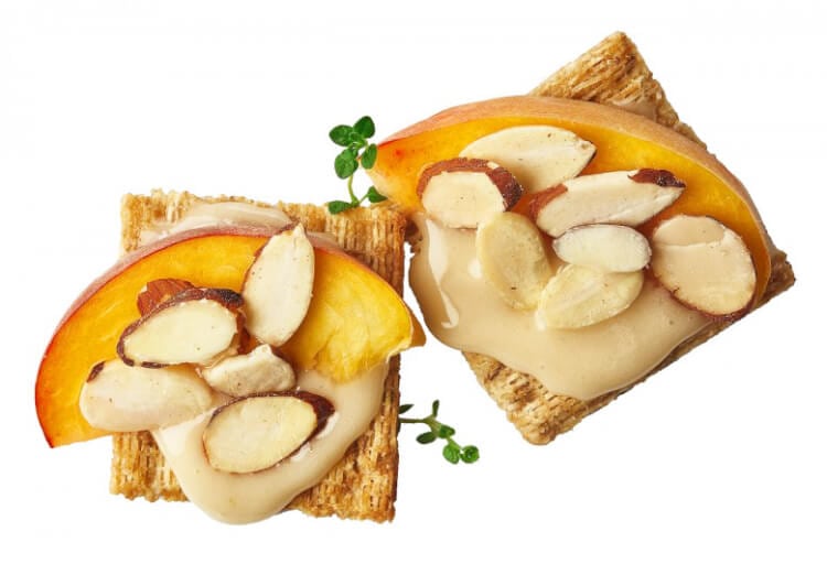 triscuit snack topped with almond butter and apples