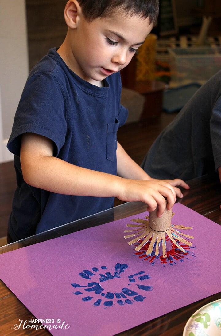 kids making fireworks using paint and frayed toilet paper tube 