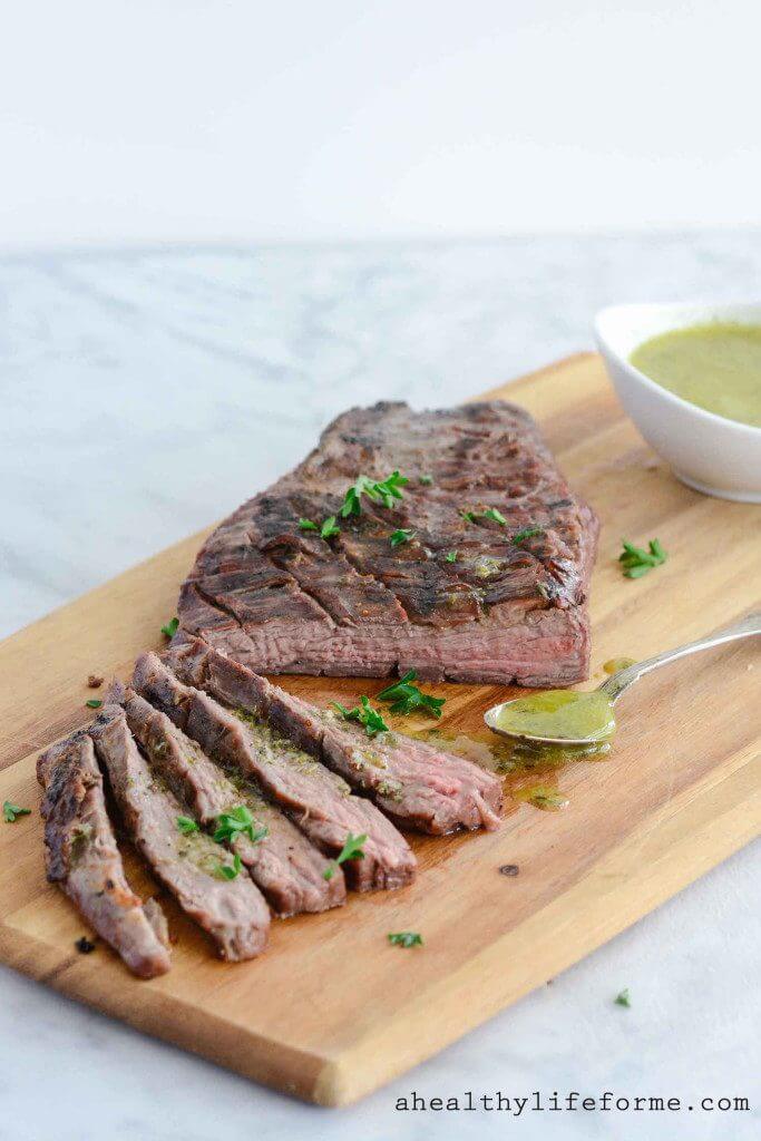 tri tip steak with sicilian herb sauce on cutting board