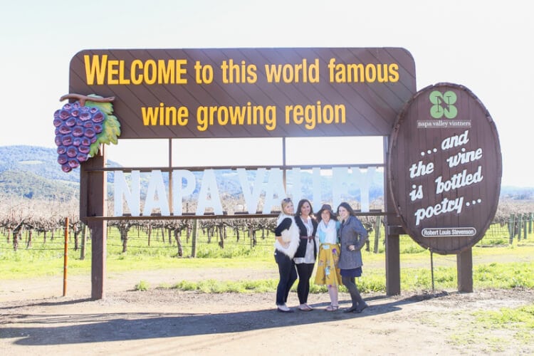 welcome to world famous wine growing region sign with ladies posed in front for picture