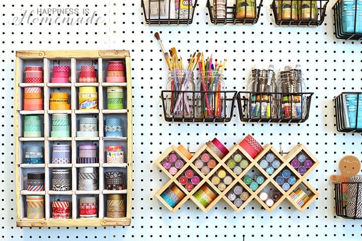 washi tapes and paints stored on craft pegboard