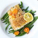 haddock garnished with lemon and roasted veggies