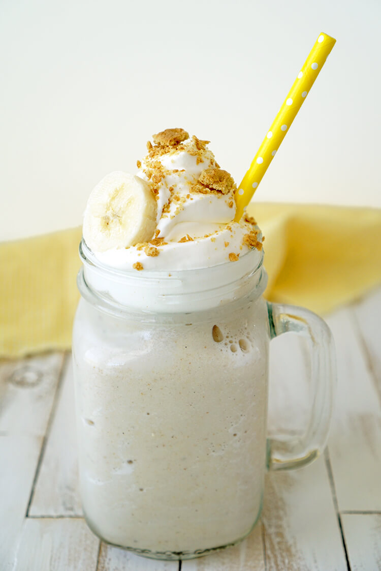 a banana smoothie in a mason jar with a yellow straw