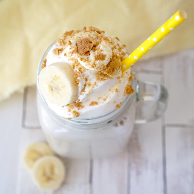 a banana smoothie in a mason jar with a yellow straw