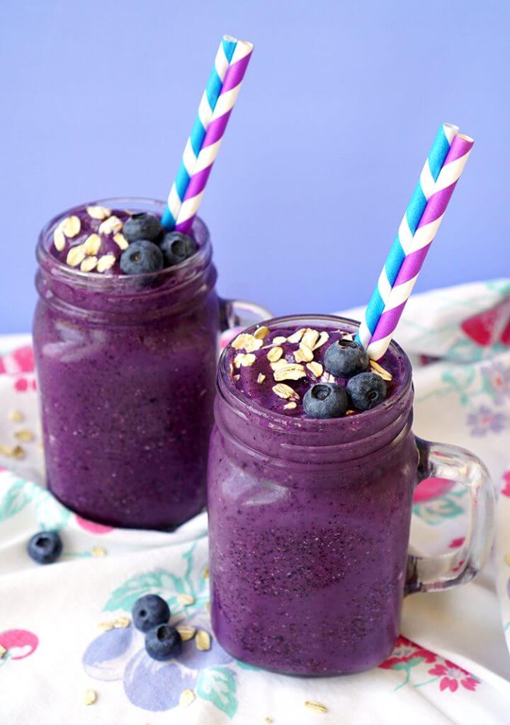healthy blueberry muffin smoothies in mason jar cups with fruits and straws 