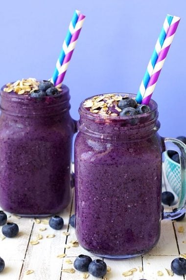 healthy blueberry muffin smoothies in mason jars with straws and toppings