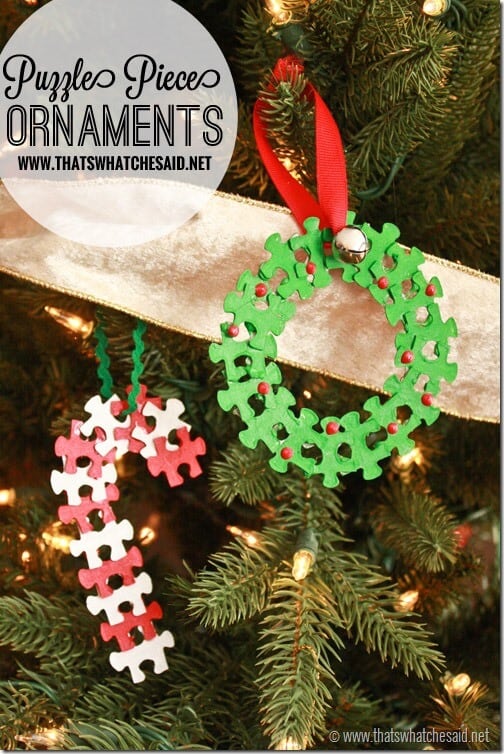 puzzle pieces made into a christmas ornament wreath and candy cane hung on tree