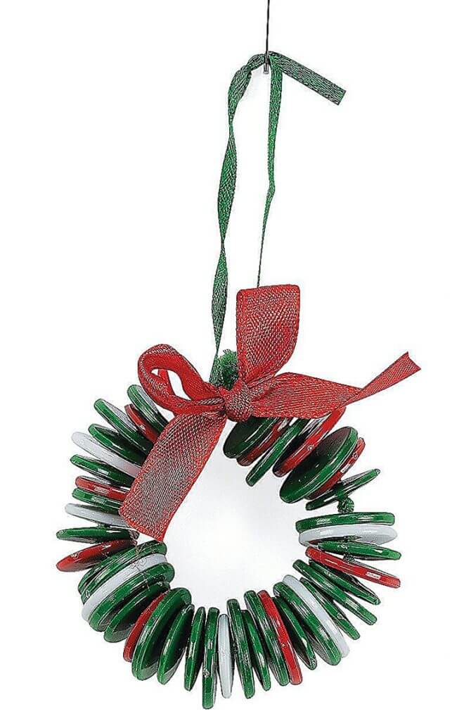 Christmas crafts for kids: button wreath Christmas ornament with red ribbon on white background 