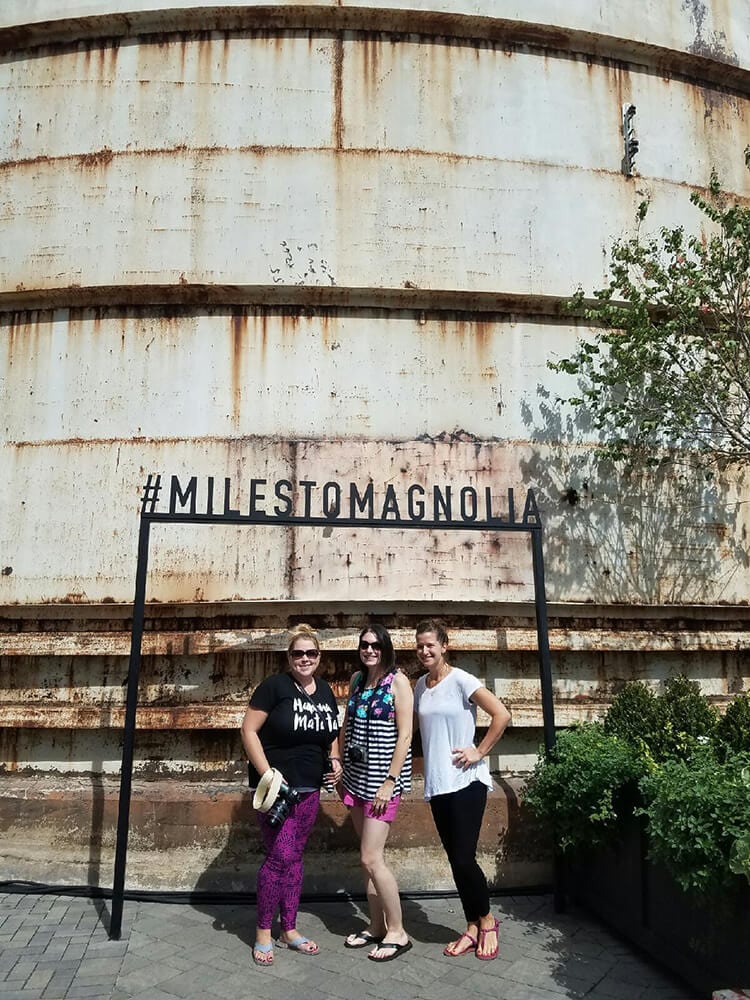 ladies posing underneath #milestomagnolia sign 