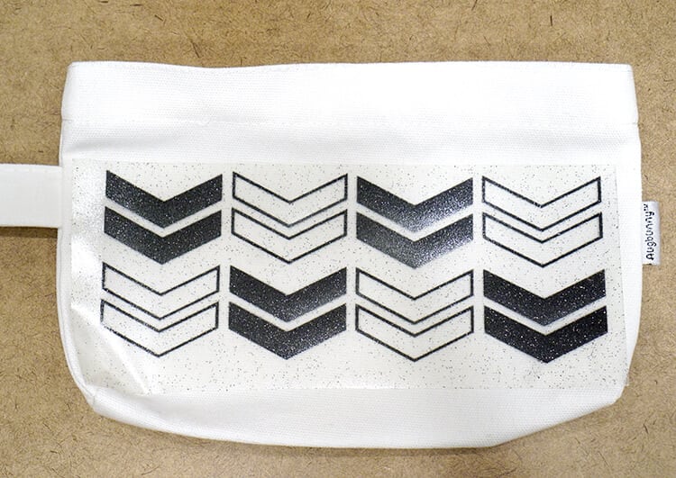 apply the weeded chevron pattern htv to a white pencil pouch 
