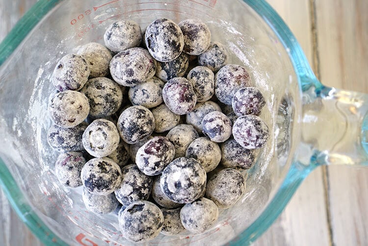blueberries dusted in flour in glass bowl