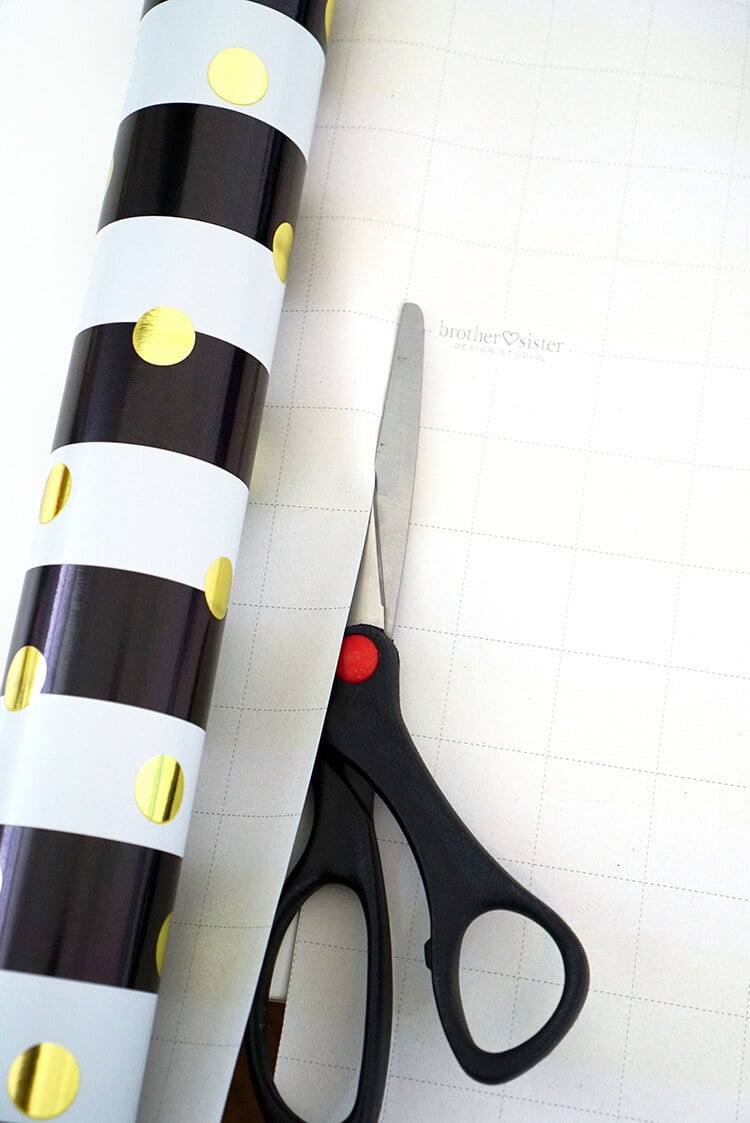 pair of scissor and roll of wrapping paper