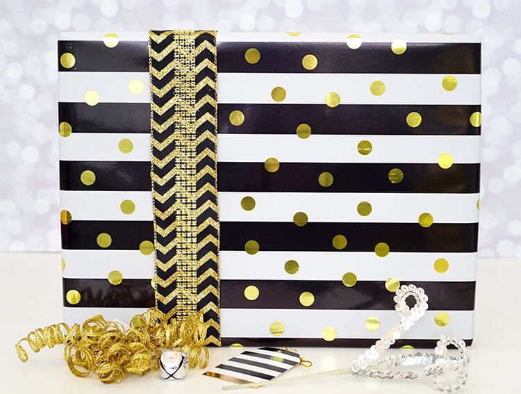 gift wrap in gold, white and black next to bows 