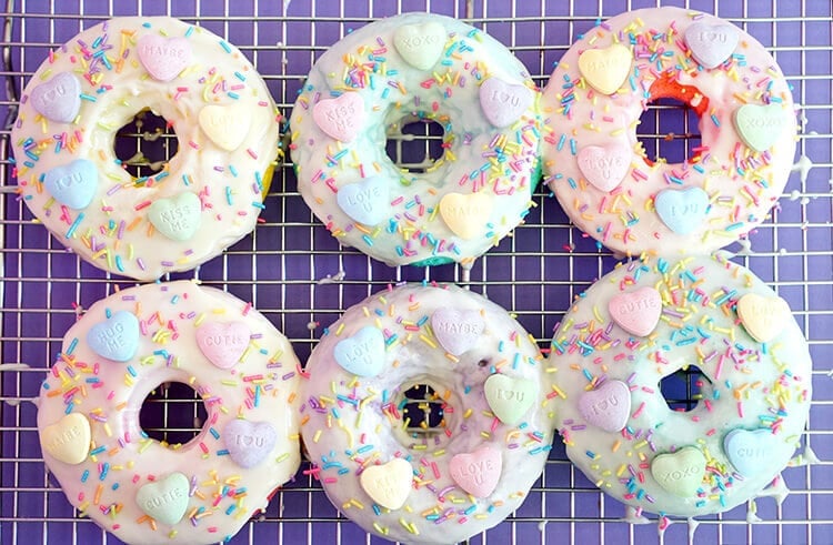 sprinkle pastel colored sweet tart baked donuts on wire rack