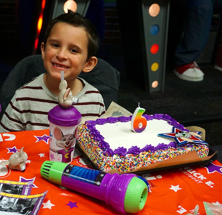 cute smiling boy enjoying birthday party at chuck e cheese