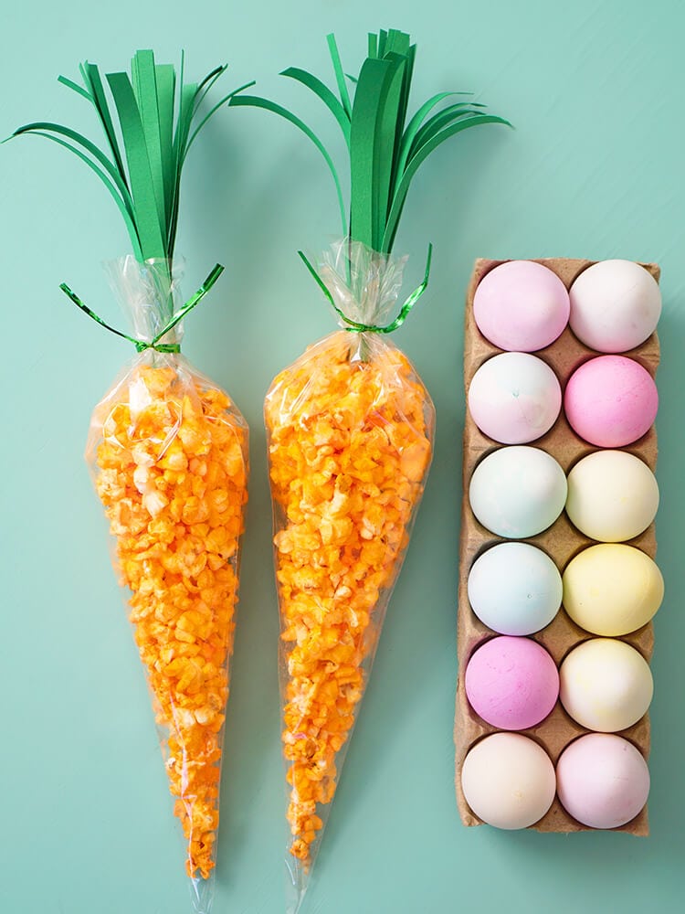 carrot treat bags for easter next to dyed easter eggs