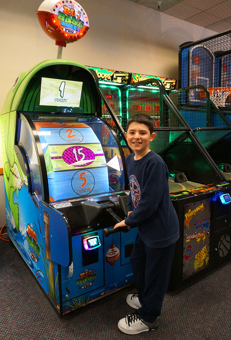 cute kid enjoying playing ticket game at chuck e cheese