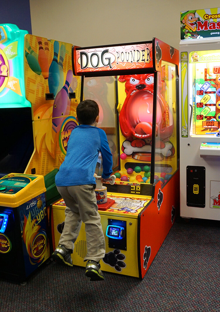 kid playing dog game at chuck e cheese\'s