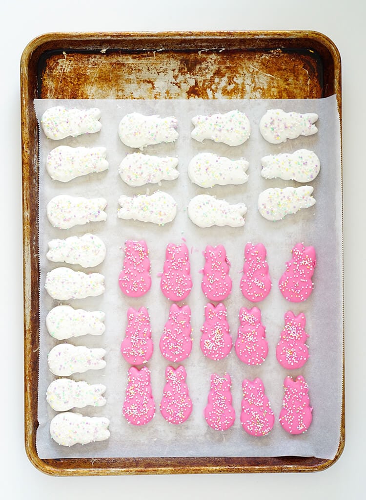 white and pink sprinkled easter bunny circus animal cookies on baking sheet