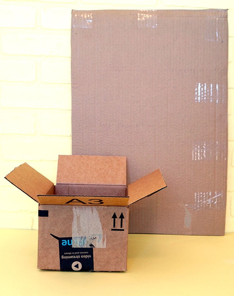 amazon box next to large piece of cardboard