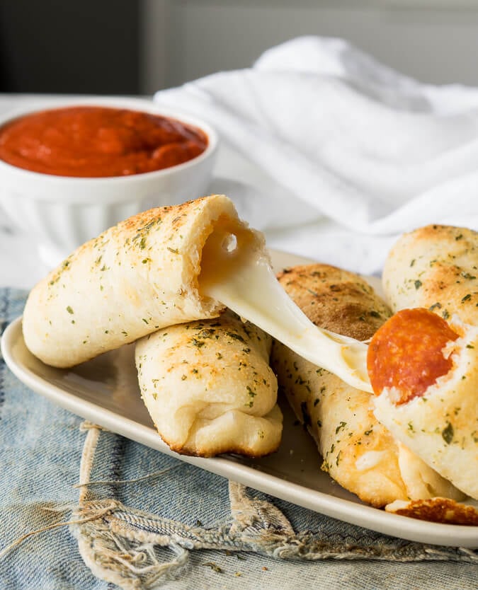 School Lunch Ideas for Kids - cheesy pizza sticks on a plate with a bowl of marinara dipping sauce
