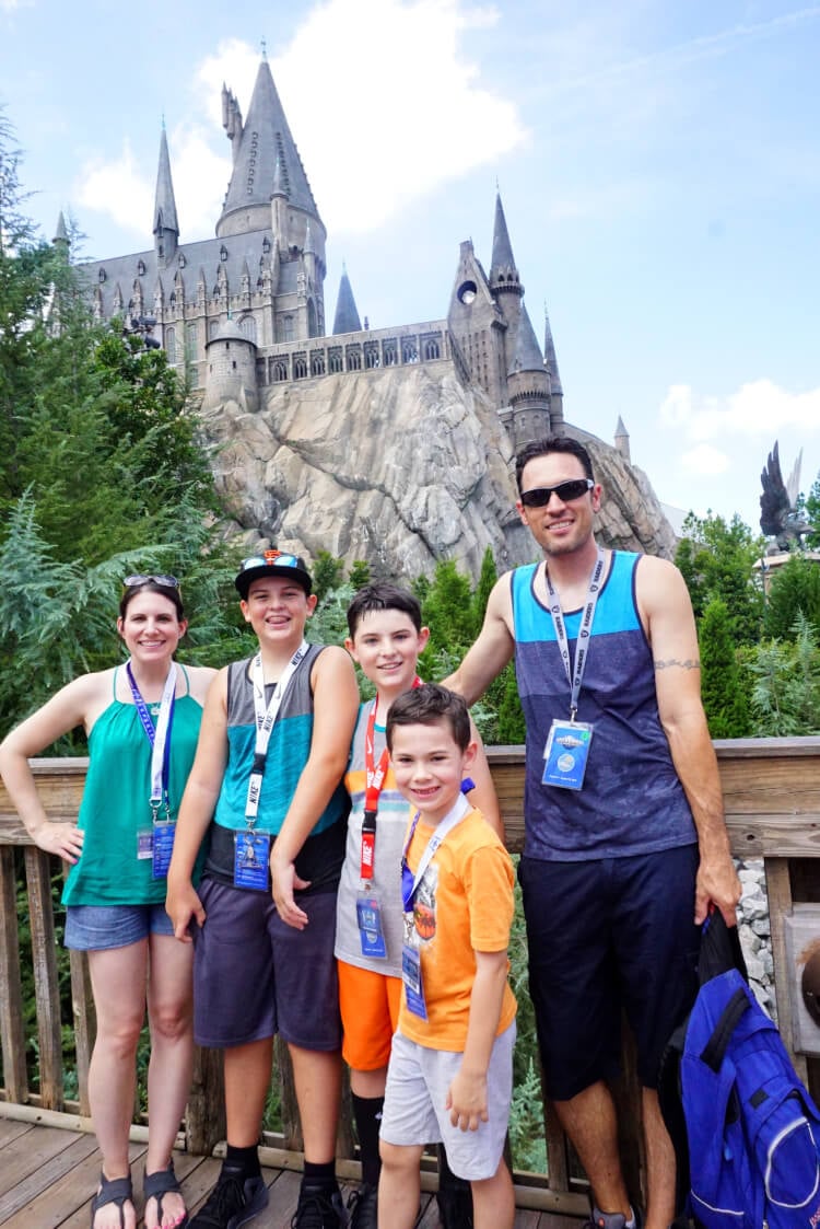 family posing in front of hogwarts castle