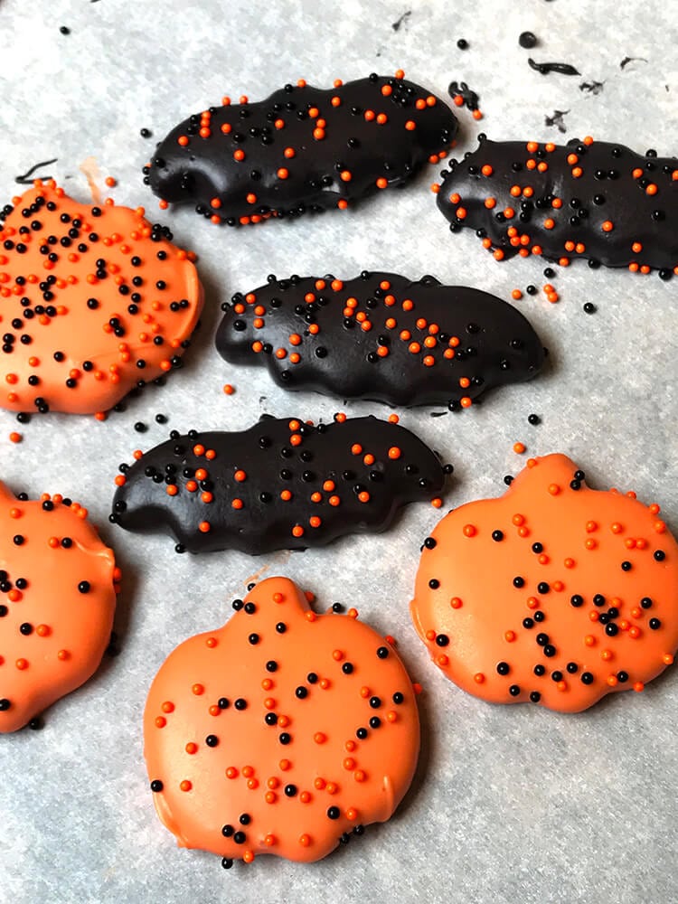 mini halloween cookies dipped in halloween colored chocolate