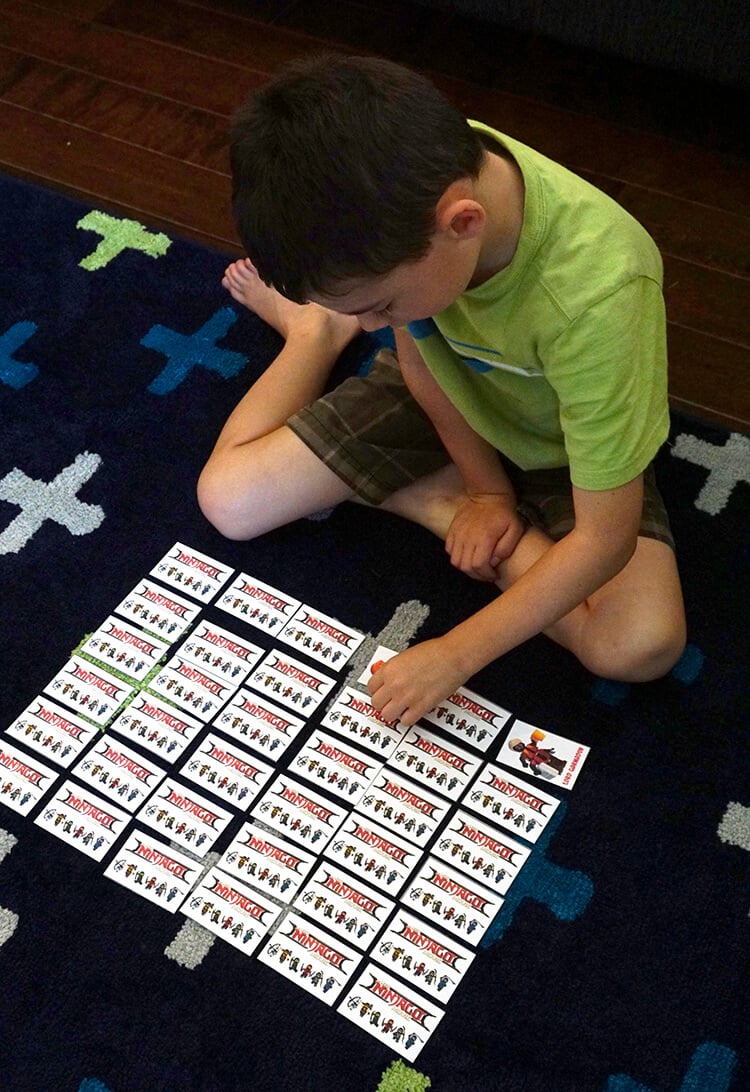 child playing lego ninjago matching character cards