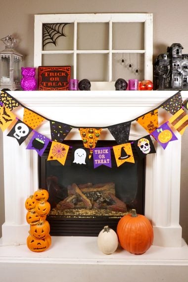 halloween banner across fireplace with halloween decorations