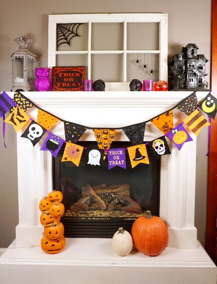 halloween banner across fireplace with halloween decorations