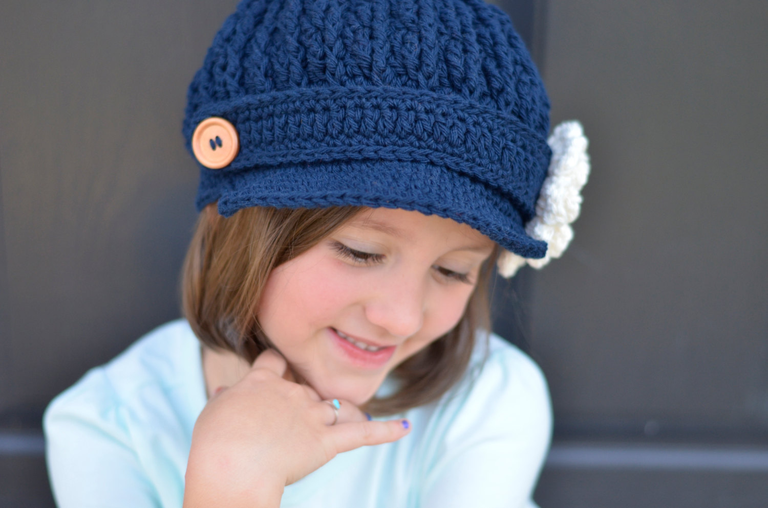 newsboy hat with crocheted flower worn by girl