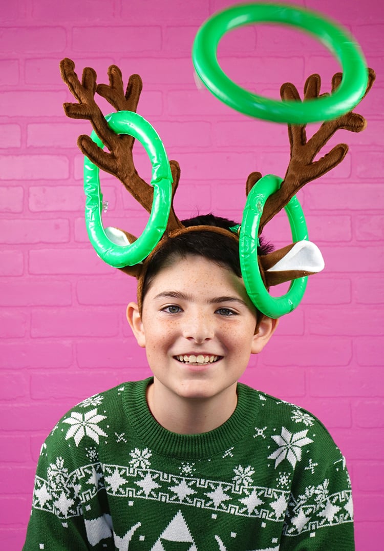 boy wearing reindeer horns with rings tossed on horns