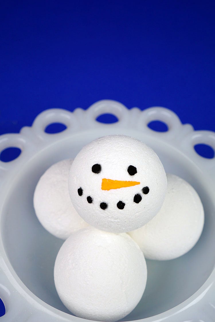 white bath bombs with snowman faces on them