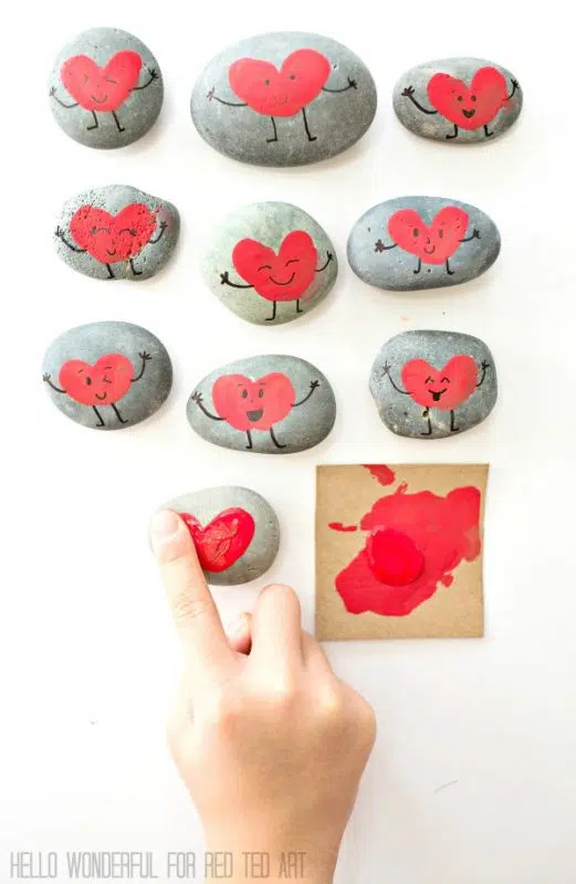 DIY finger print heart art rocks being made