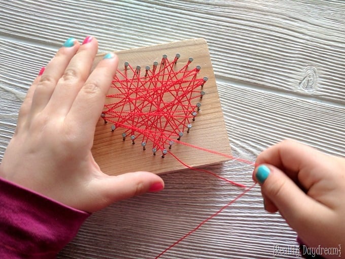 little hands making string art heart