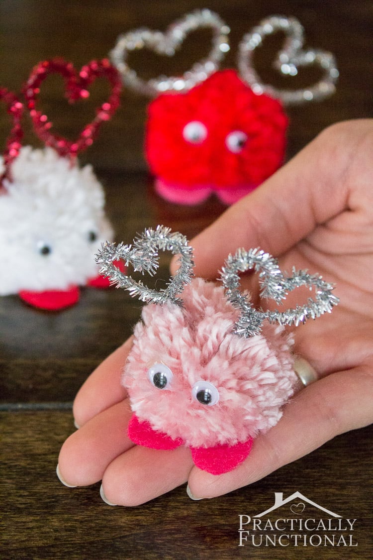 hand holding diy pom pom monsters