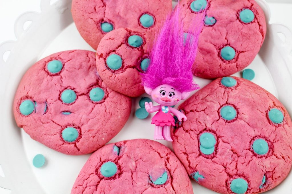 troll doll nestled in between pink and blue cookies 