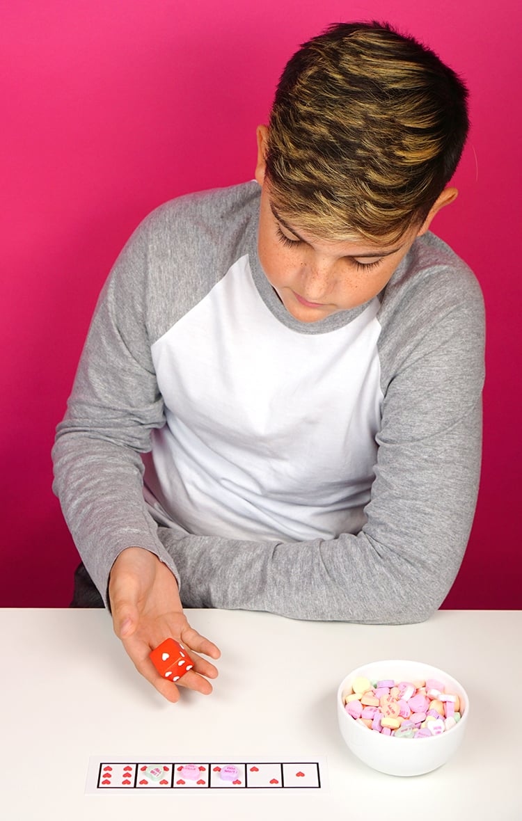 kid playing roll and cover dice game 