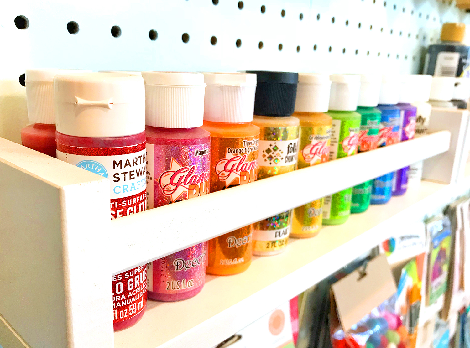 colorful paint organized on peg board