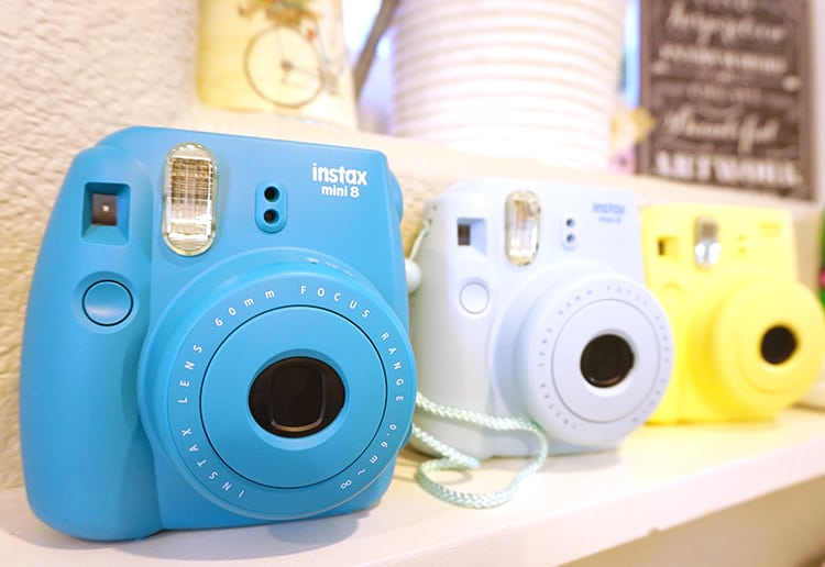 instax colored cameras on shelves